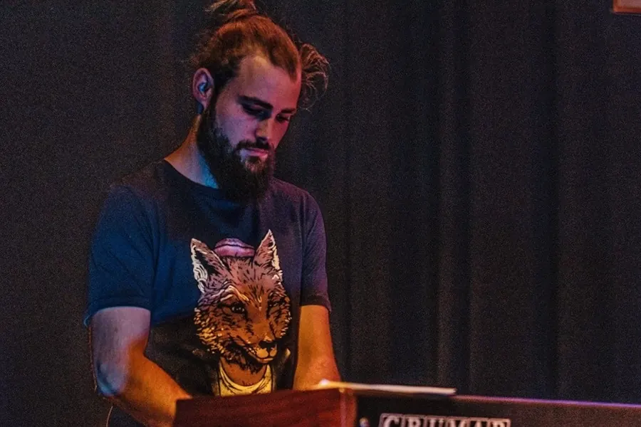 Valentin au synthé, penché sur son instrument.